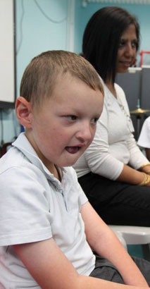 a young stressed boy with his hands over
                  his ears