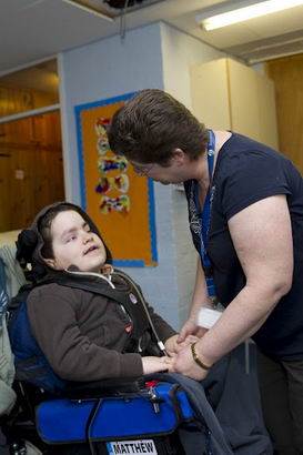 Boy in wheelchair with two teaching
                  assistants/nurses