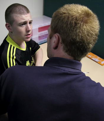 A teenage boy speaks with his teacher
                  during a diagnostic review