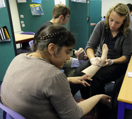 A physiotherapist works on a girl's foot