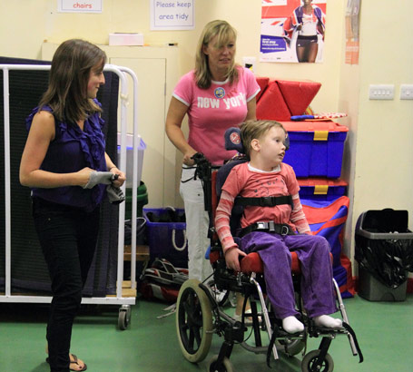 Two carers with a child in a wheelchair