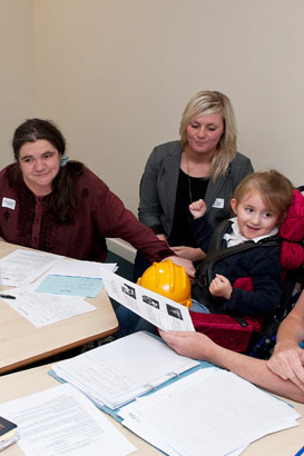 A disabled girl in a meeting alongside
                  teachers and professionals