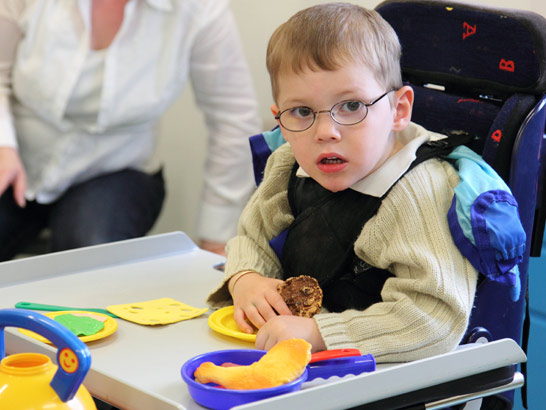 A boy with a tray of items looks at the
                  camera