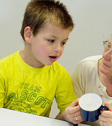 A boy and his teacher with a cup