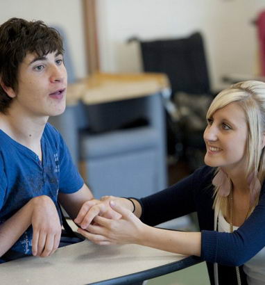 A boy and his teacher in class