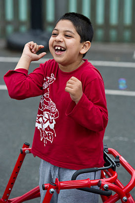 A boy with a walking frame laughing