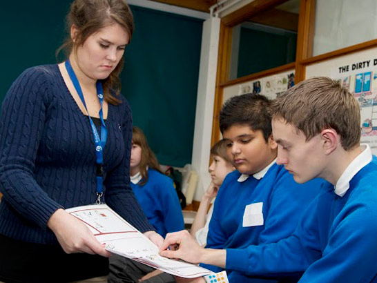 Teacher oversees two pupils studying.