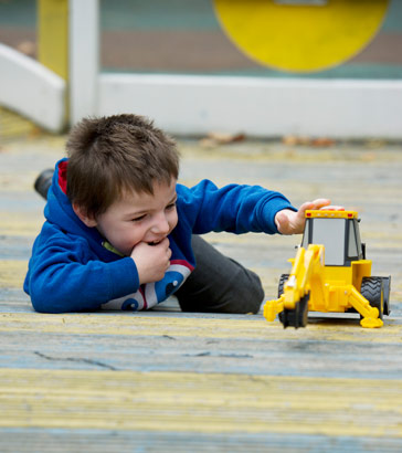 Boy playing with toy car.