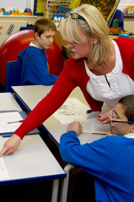Teacher helping pupils with assignment.