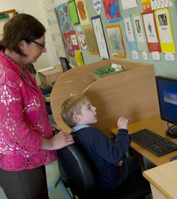 Boy with teacher on the computer