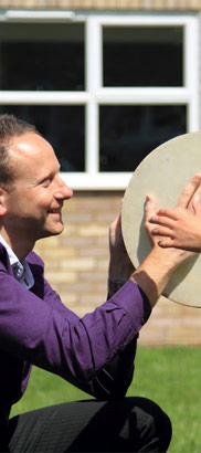 teacher and child both use a drum