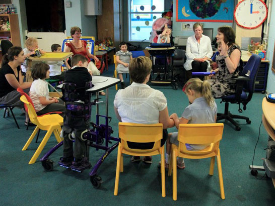 Carer interacting with disabled girl.