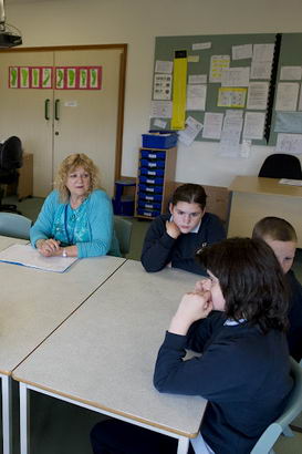 Teachers and pupils sat round a
                  classroom table