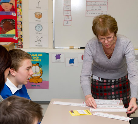 An English teacher arranges some
                  paper sentences on a table