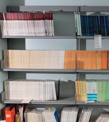 Library shelves containing research reports
                  and journals
