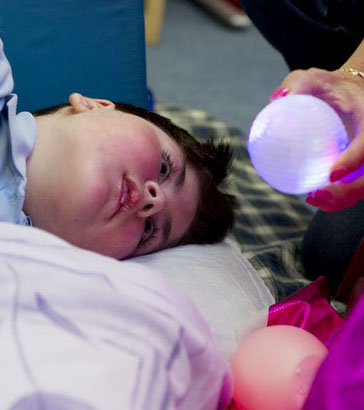 Using a ball a teacher interacting with a boy