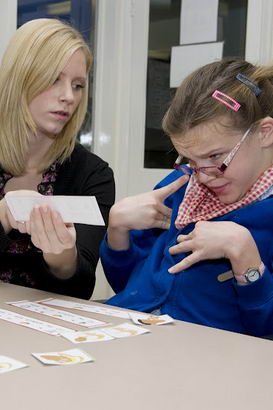 A girl and her teacher work through a sequence of instructions