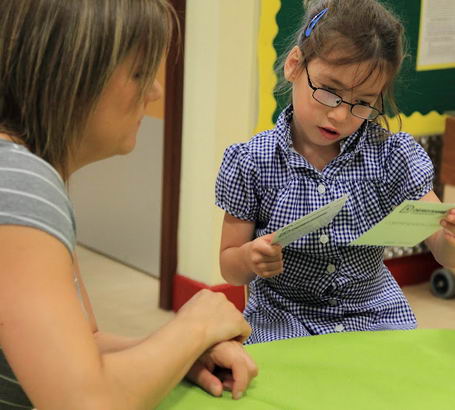 A girl inspects two cards