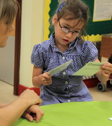 A girl inspects two cards