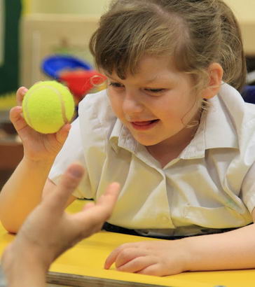 A girl holds a tennis ball